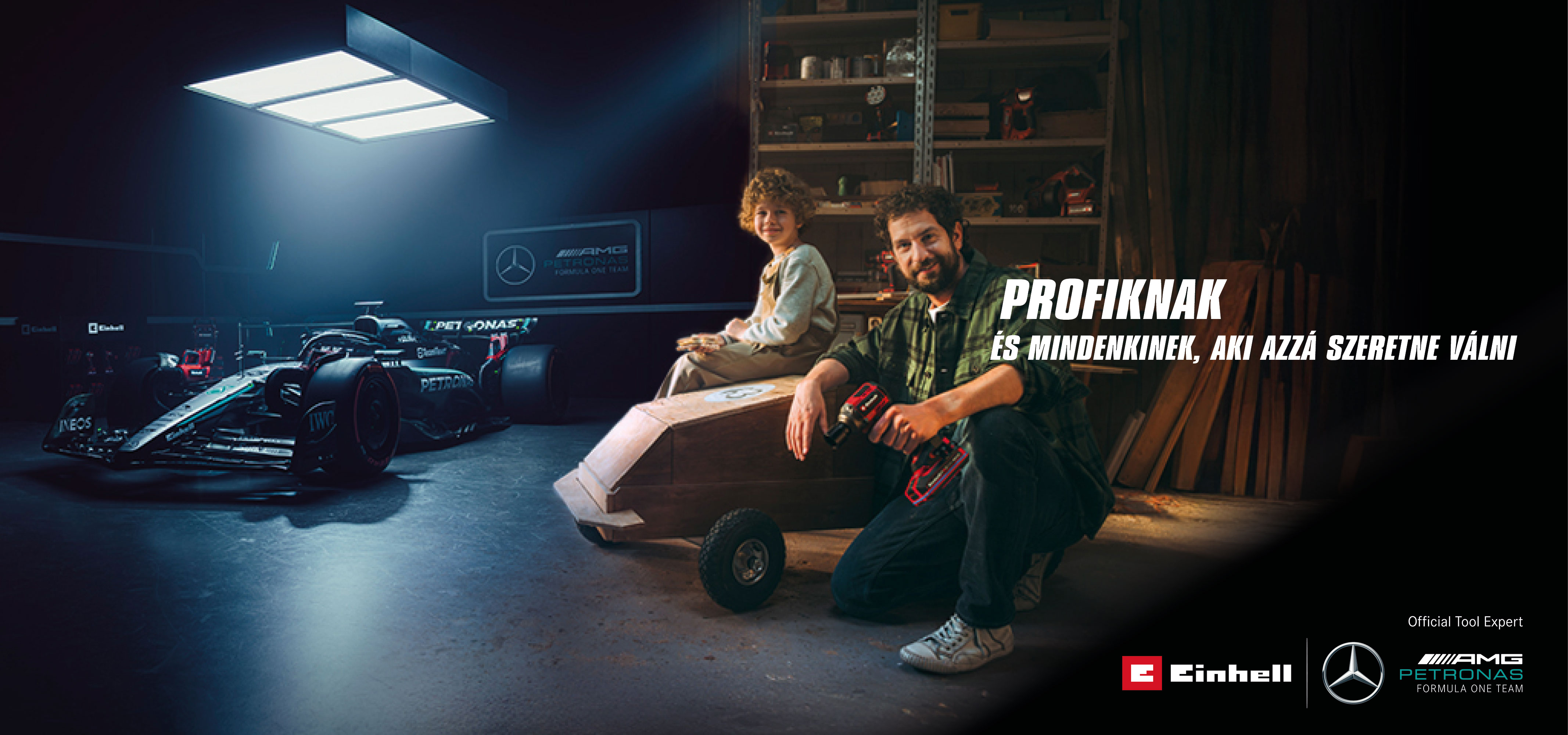 Egy apa és gyermeke egy műhelyben egy házilag készített szappantartó autóval. A háttérben egy Mercedes-AMG PETRONAS Forma–1-es autó és Einhell szerszámok. Jobbra a szöveg olvasható: „A profiknak és azoknak, akik azzá akarnak válni.”