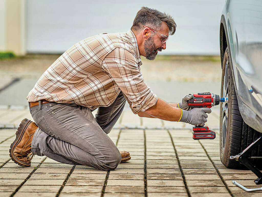 A man screws on a car tire