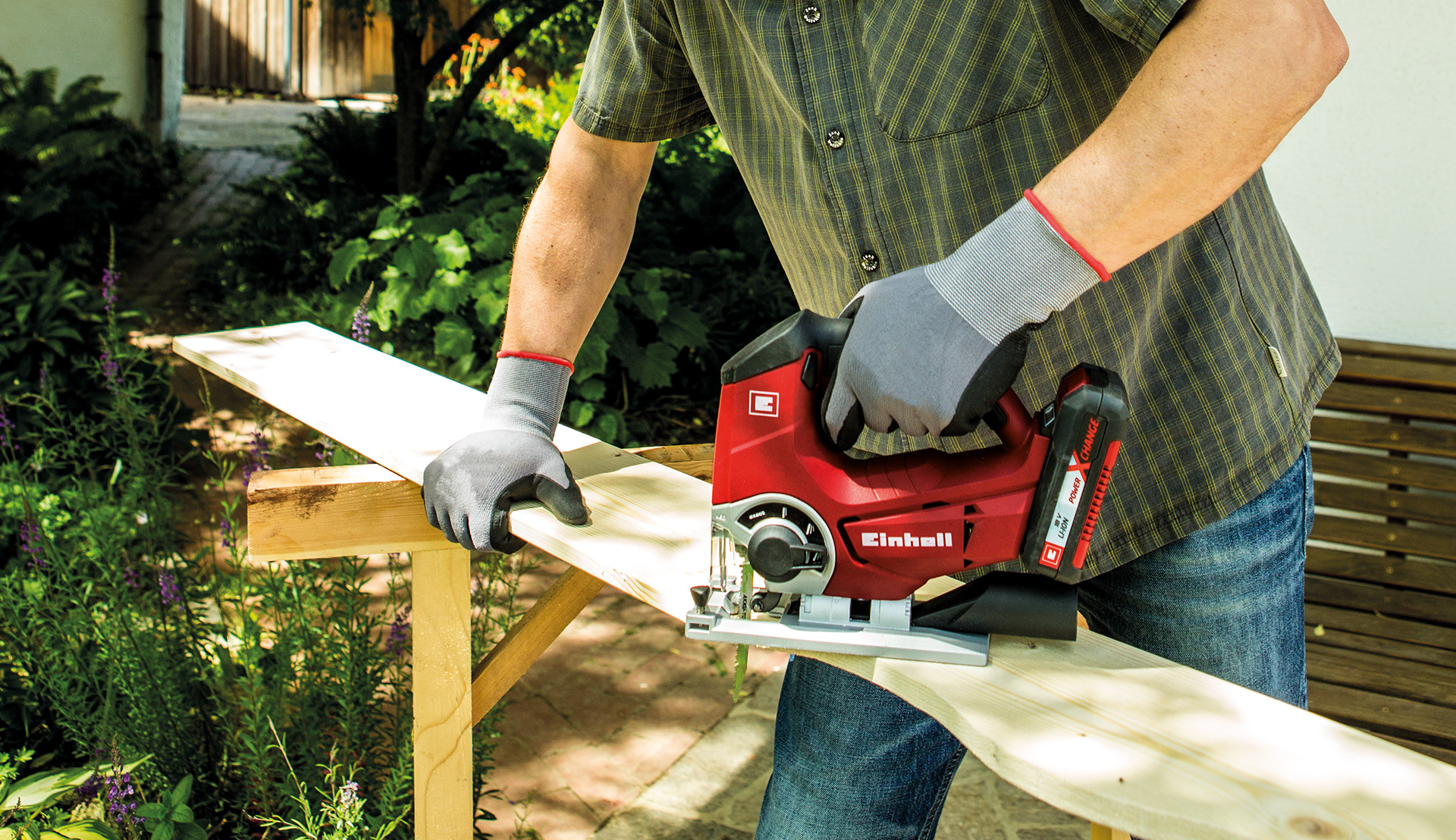 A man cuts a board with a jigsaw