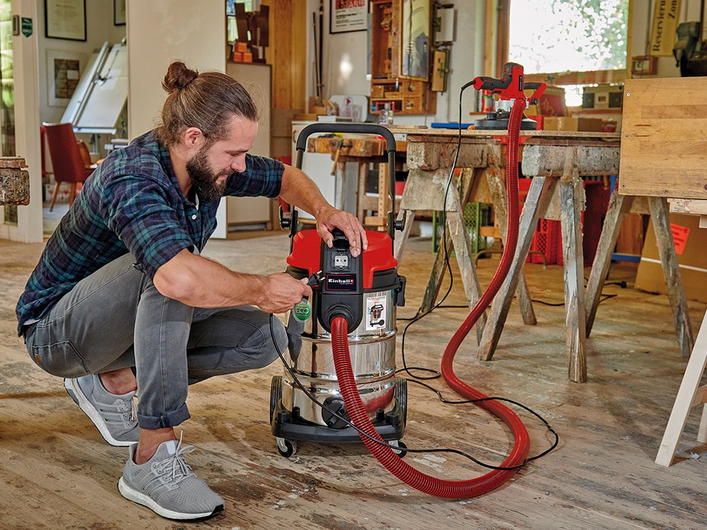 man plugs vacuum cleaner