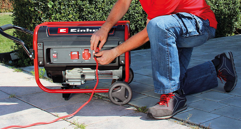 man connecting cable on power generator